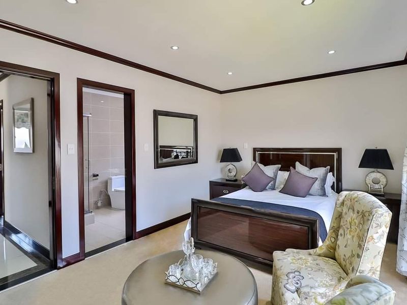 A well-maintained bedroom featuring recessed lighting, crown molding, and an adjoining en-suite bathroom with tiled flooring.