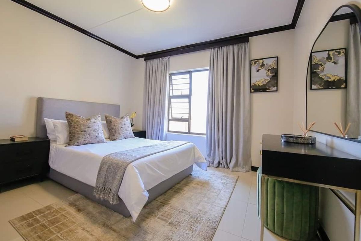 A well-maintained bedroom featuring tiled flooring, neutral walls, and a window with curtains, providing a clean and comfortable living space.