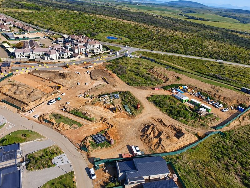 Aerial view of a residential development site showing ongoing earthworks, excavation, and site preparation within a gated community setting.