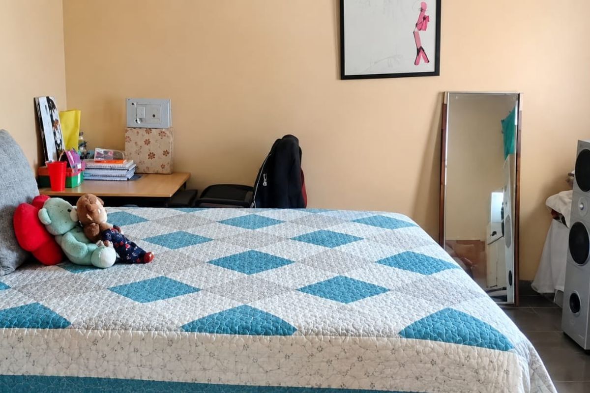 A standard bedroom featuring tiled flooring and neutral wall paint, providing a functional space for rest.