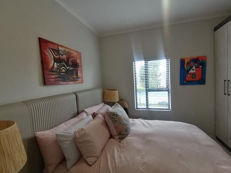 A well-maintained bedroom featuring a built-in wardrobe and a window with fitted blinds, providing natural light and functional storage space.