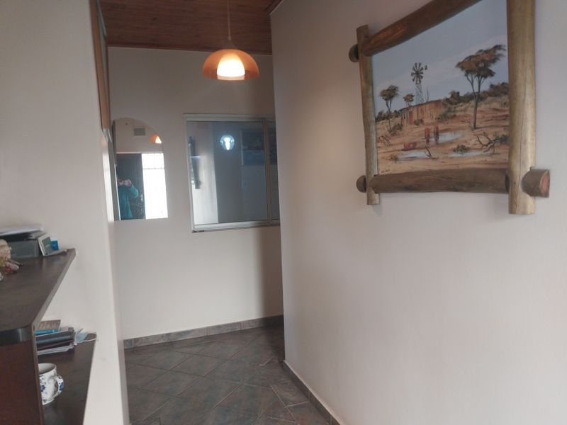 A functional hallway featuring tiled flooring, a timber-paneled ceiling, and a pendant light fixture, providing a neutral transition space within the home.