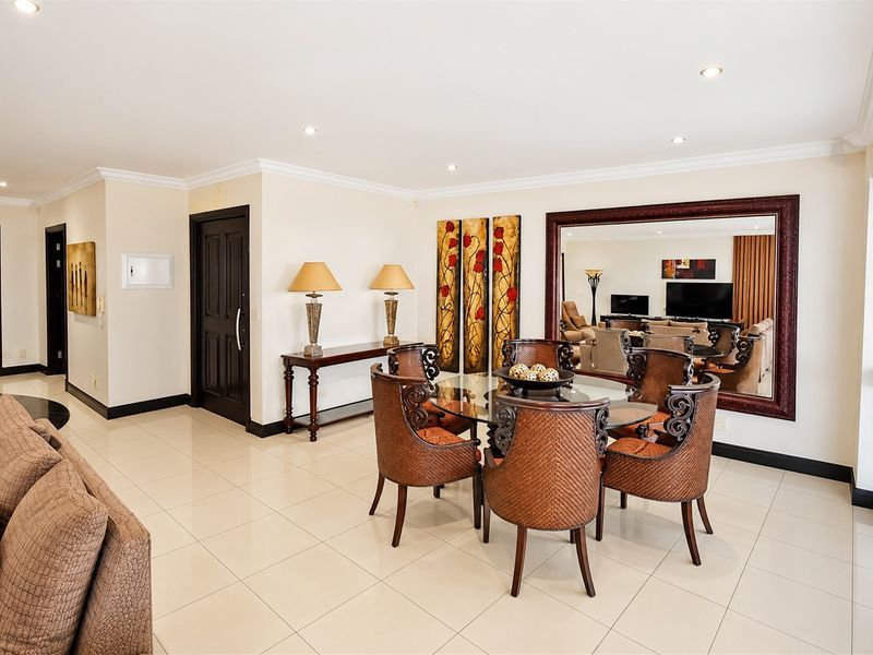 Spacious open-plan living and dining area featuring neutral tiled flooring, recessed lighting, and large sliding glass doors providing ample natural light.