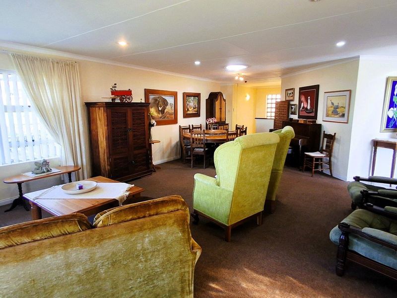 Spacious open-plan living and dining area featuring neutral walls, carpeted flooring, and recessed lighting, offering a versatile layout for family living.
