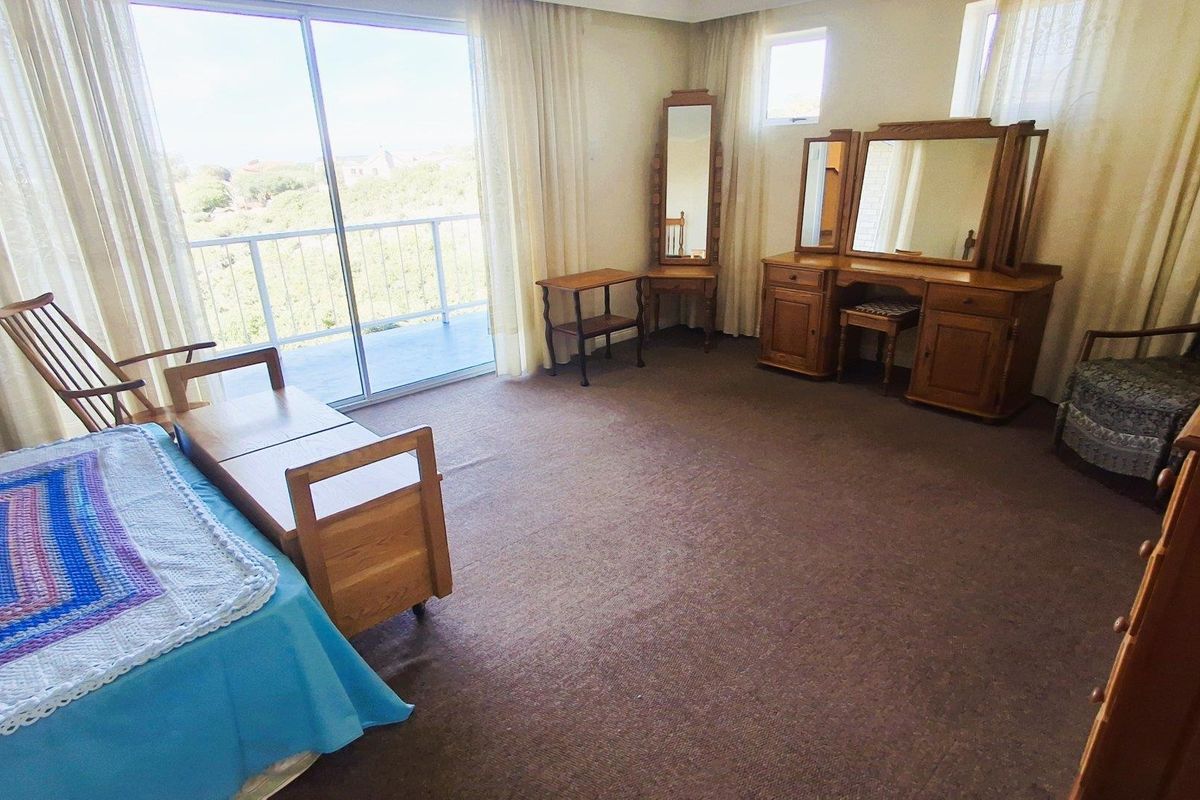 Spacious bedroom featuring carpeted flooring and large sliding glass doors that open onto a private balcony, providing natural light and outdoor access.