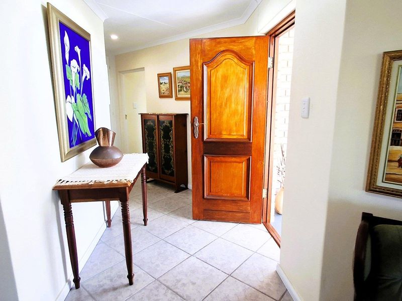 A welcoming entrance hall featuring tiled flooring and a solid timber front door, providing a bright and functional transition space into the home.