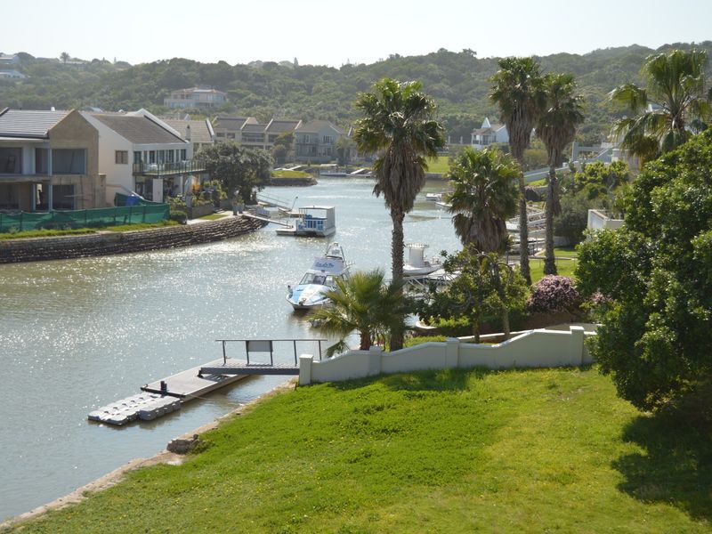 Scenic elevated view overlooking the canal, private jetty, and surrounding residential estate landscape.