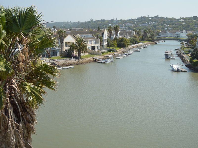 Scenic elevated view overlooking the canal, private jetties, and surrounding residential estate properties.