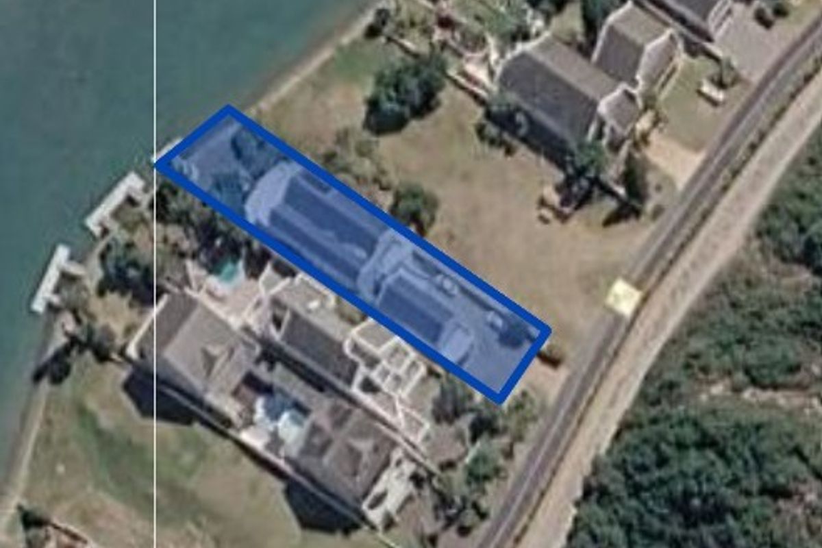An aerial view of the property highlighting the building footprint, swimming pool, and waterfront location.