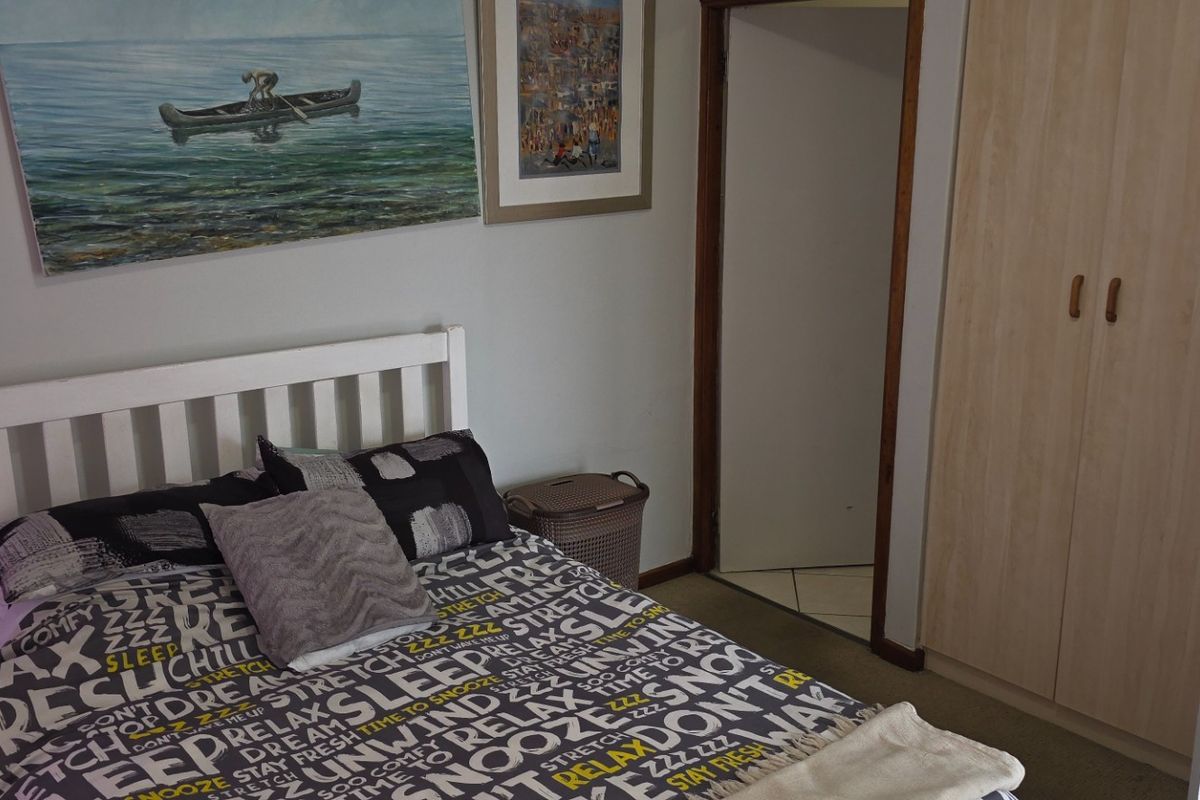A bedroom featuring a built-in wardrobe with light wood-finish doors and neutral wall tones.