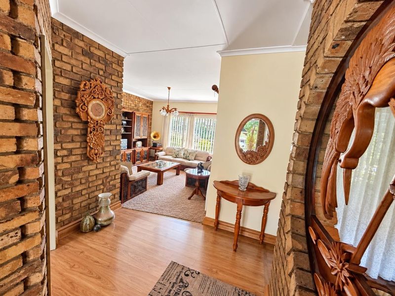 Welcoming entrance hall featuring exposed brick feature walls and laminate flooring, leading directly into the open-plan living area.