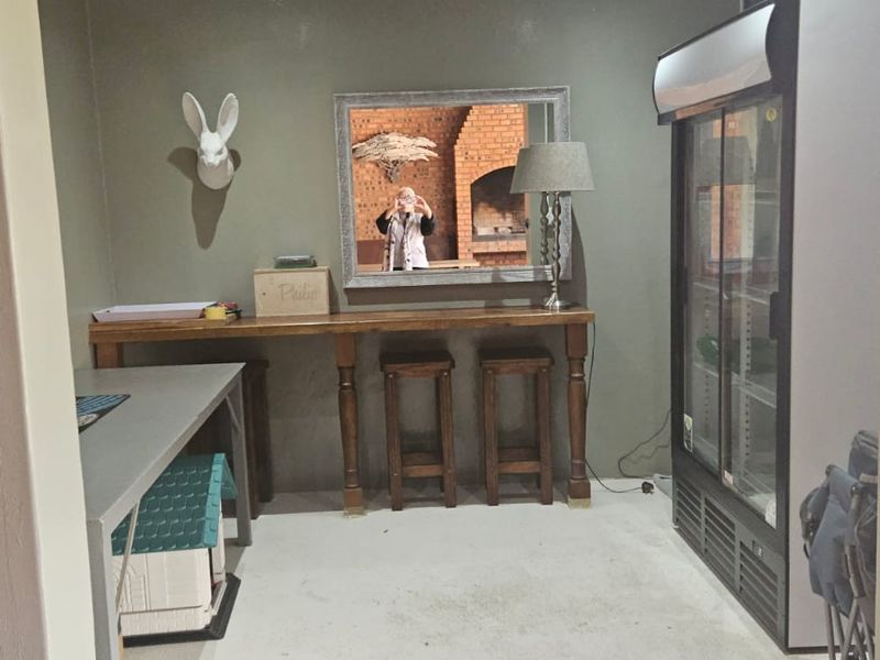A dedicated bar area featuring a built-in counter and a glass-door display fridge, providing a functional space for entertaining.