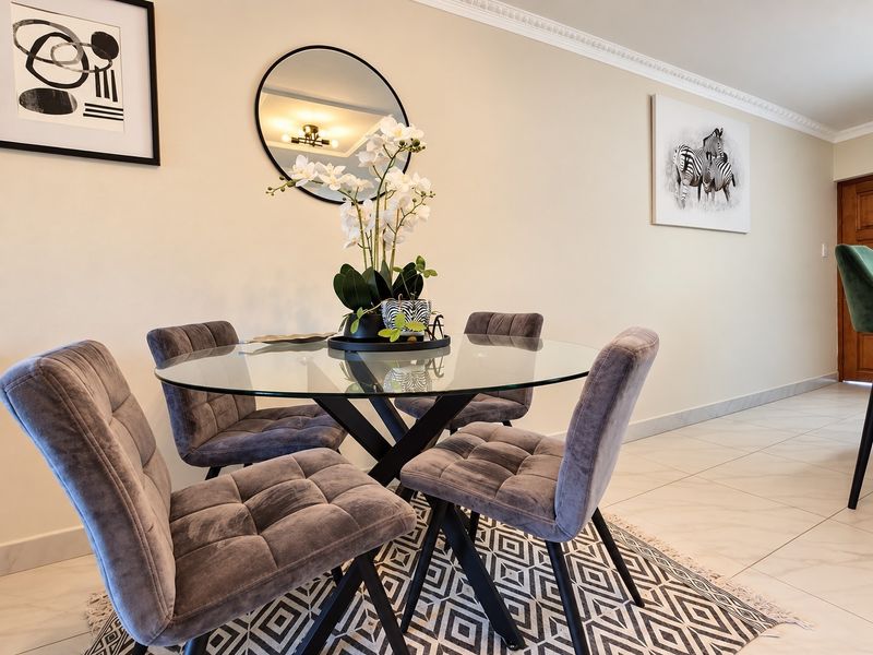 A well-maintained dining area featuring elegant crown molding and clean tiled flooring, creating a bright and inviting space for meals.