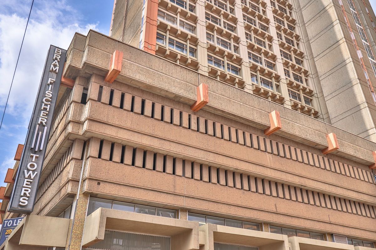 Exterior view of Bram Fischer Towers, a multi-story commercial building featuring a prominent concrete facade and vertical signage.