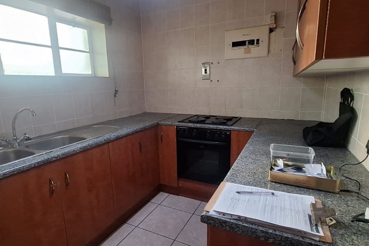 A functional kitchen featuring built-in cabinetry, laminate countertops, a double bowl sink, and a built-in oven with hob.