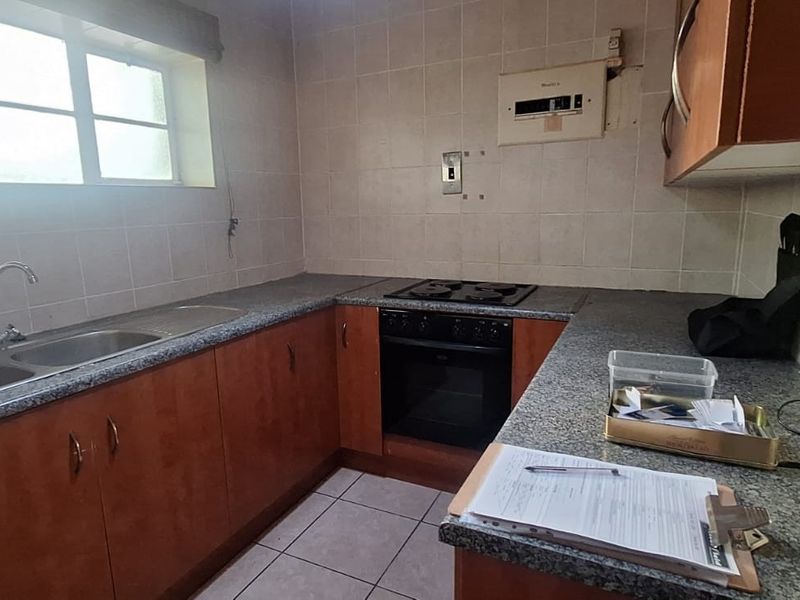A functional kitchen featuring built-in cabinetry, laminate countertops, a double bowl sink, and a built-in oven with hob.