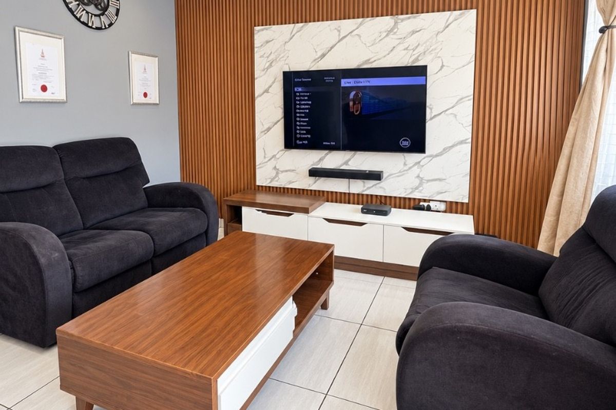 Modern living room featuring a stylish timber slat feature wall with marble-look paneling, recessed downlights, and neutral tiled flooring.