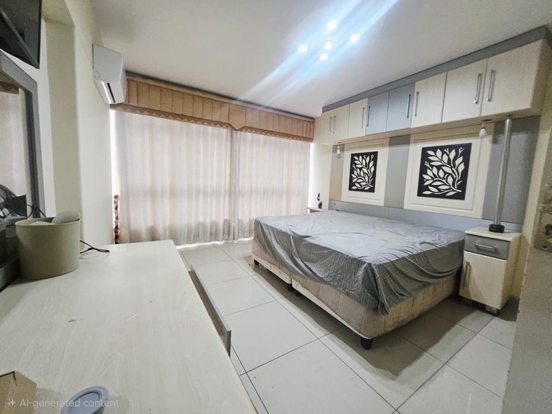 A bedroom featuring built-in overhead cabinetry, tiled flooring, and a wall-mounted air conditioning unit.