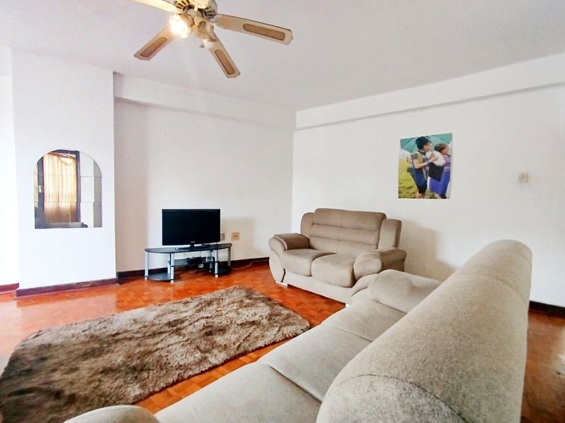 A living room featuring parquet flooring, a ceiling fan, and a decorative archway, providing a functional and neutral space.