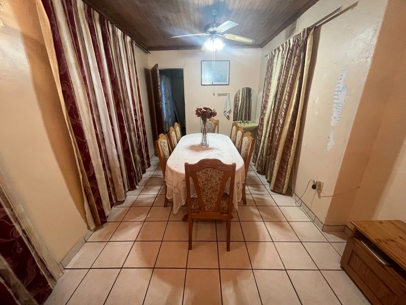 Dining room featuring tiled flooring, a timber ceiling with a central fan, and wall-mounted lighting.