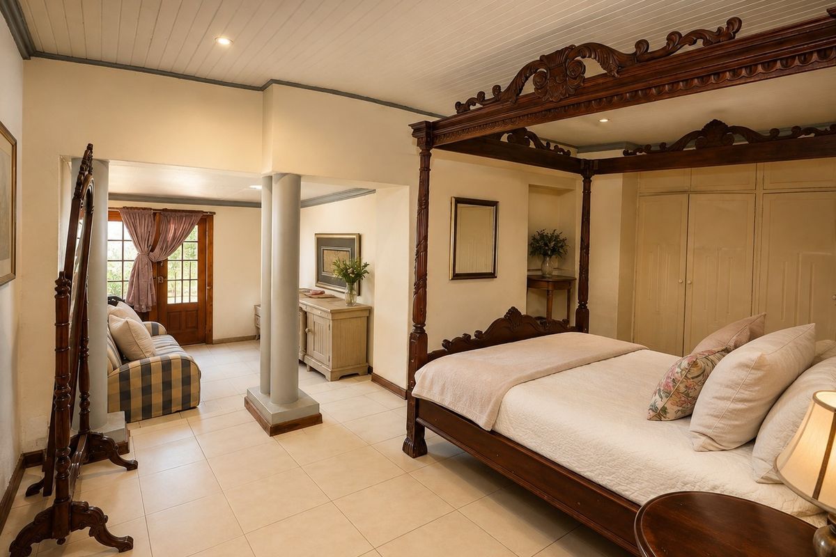 Spacious bedroom featuring tiled flooring, timber ceiling, built-in cupboards, and an adjoining seating area with access to an exterior door.