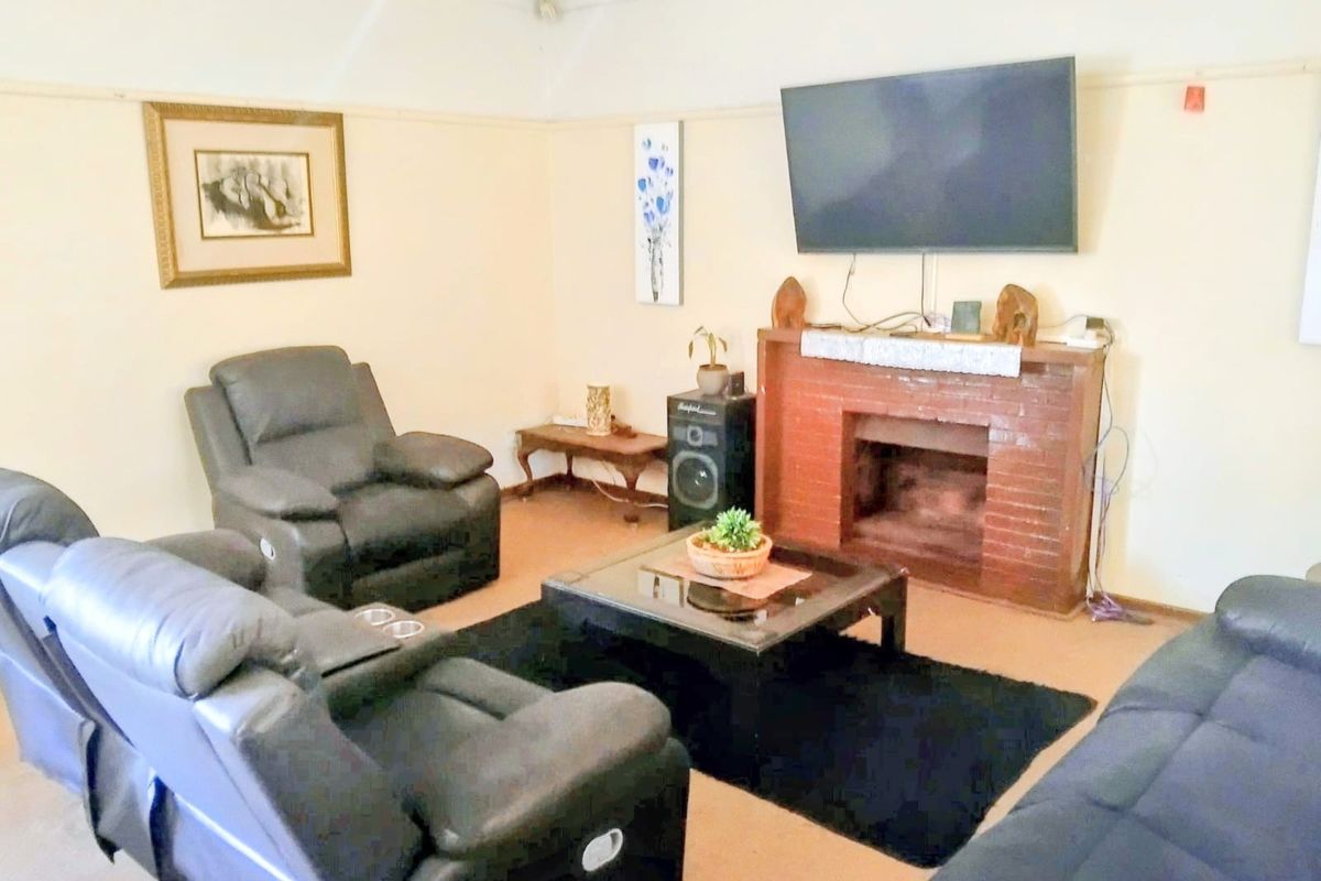 A living room featuring a traditional brick fireplace and classic picture rail detailing, offering a comfortable space for relaxation.