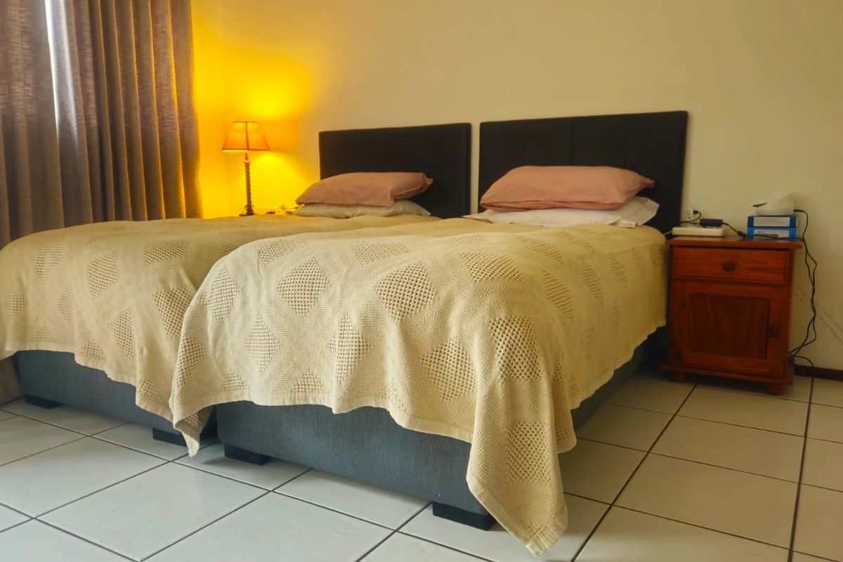 A bedroom featuring tiled flooring and neutral wall finishes, providing a functional sleeping space.