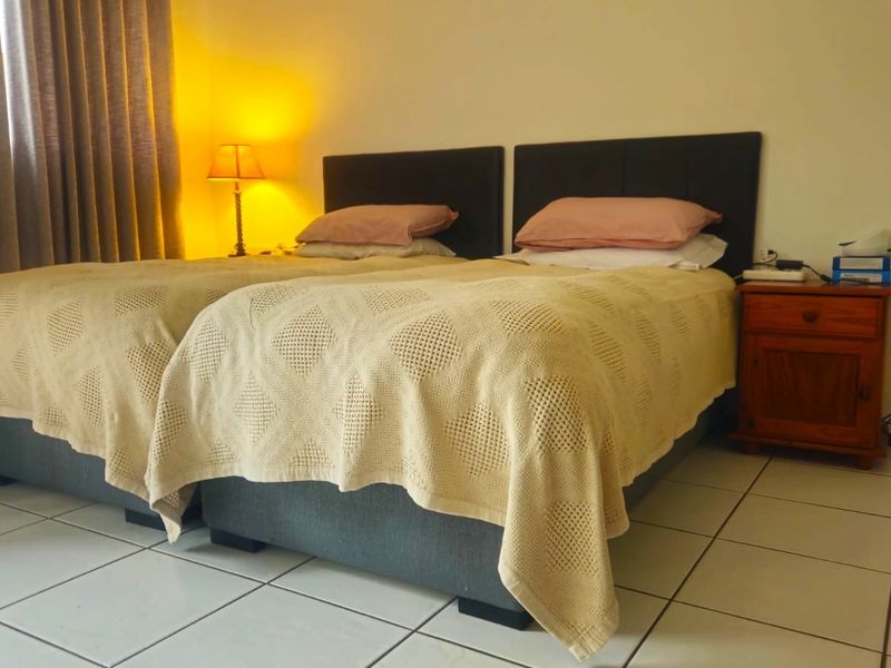 A bedroom featuring tiled flooring and neutral wall finishes, providing a functional sleeping space.