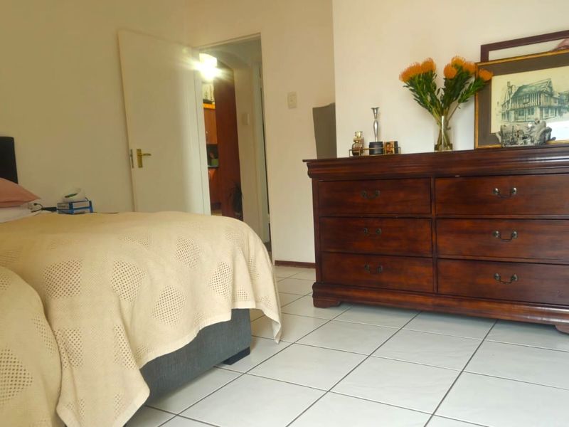A bedroom featuring tiled flooring and access to an adjoining room, providing a functional living space.