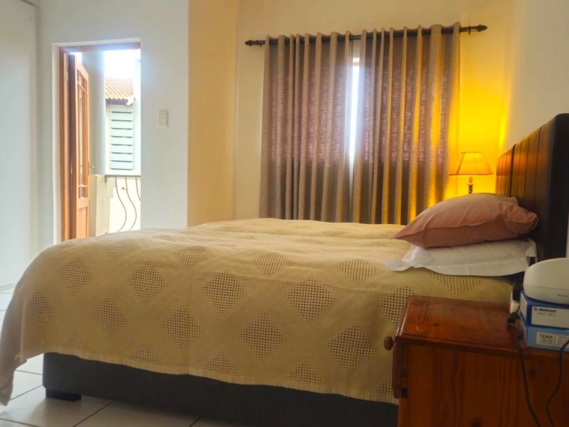 A bedroom featuring tiled flooring, a built-in wardrobe, and direct access to an outdoor balcony area.