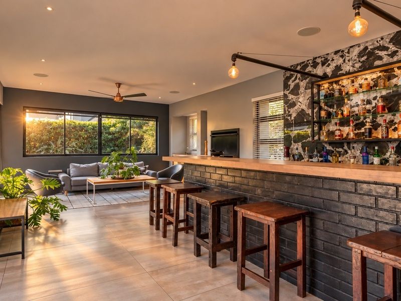 Modern entertainment area featuring a built-in bar with marble-look backsplash, tiled flooring, recessed lighting, and a cozy fireplace, perfect for hosting.