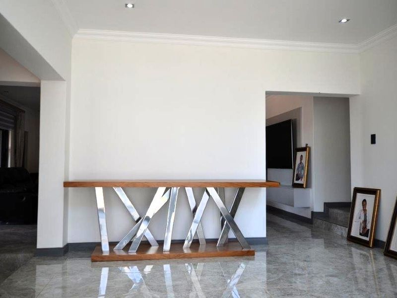 A bright living area featuring polished tiled flooring, recessed downlighting, and decorative coving, providing a clean and modern foundation for the home.