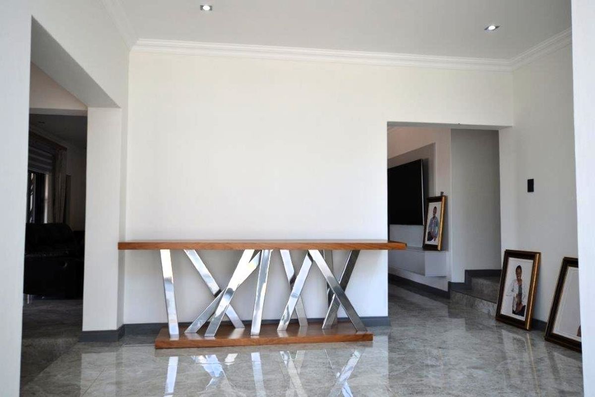 A bright living area featuring polished tiled flooring, recessed downlighting, and decorative coving, providing a clean and modern foundation for the home.