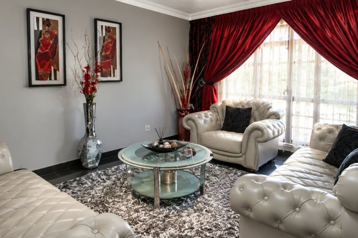 A comfortable living room featuring tiled flooring and crown molding, providing a neutral base for interior design.