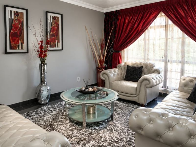 A comfortable living room featuring tiled flooring and crown molding, providing a neutral base for interior design.