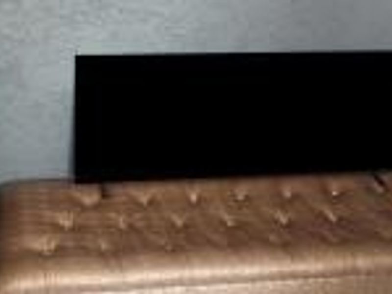 A close-up view of a bedroom area showing a textured wall and furniture.