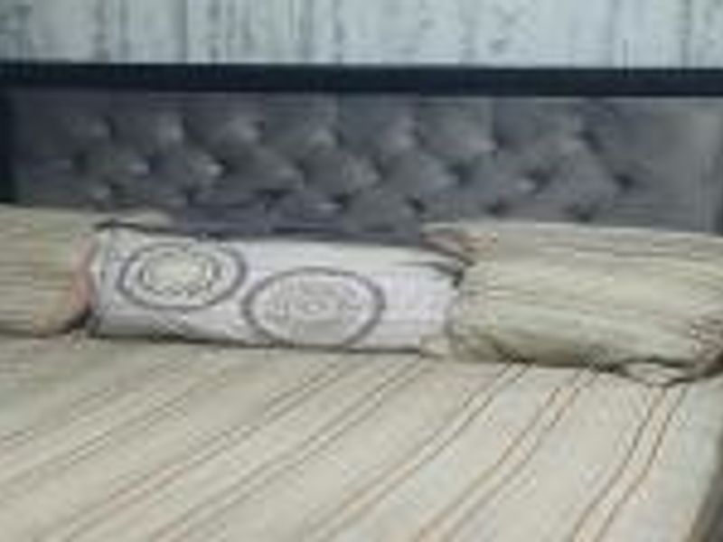 A close-up view of a bedroom space focusing on the bed area.