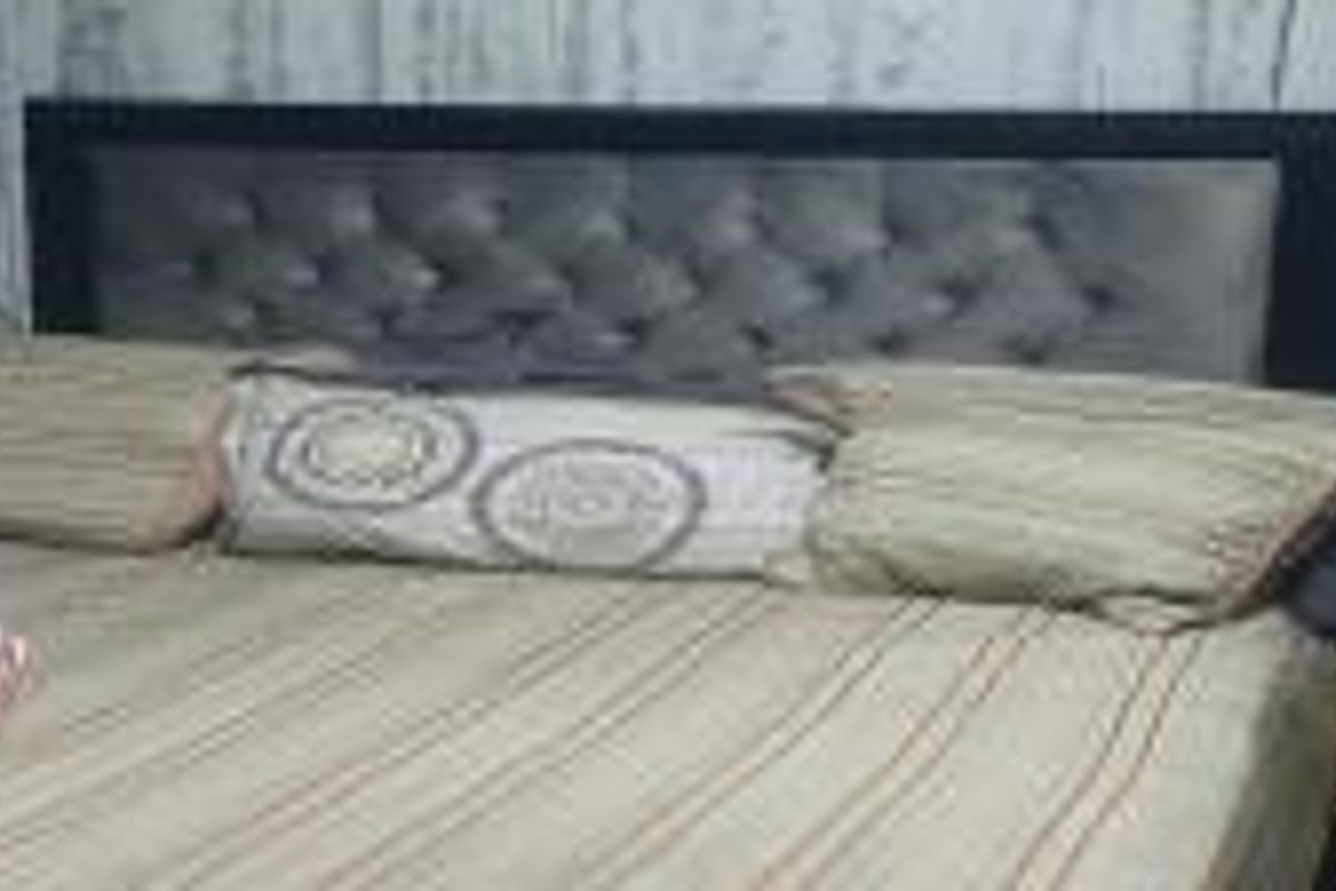 A close-up view of a bedroom space focusing on the bed area.
