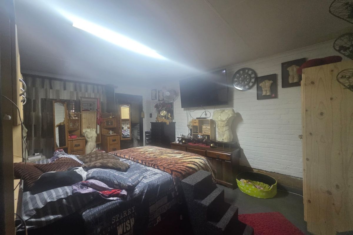 A bedroom featuring a painted brick wall and fluorescent lighting, requiring cosmetic updates to improve the overall aesthetic and finish.