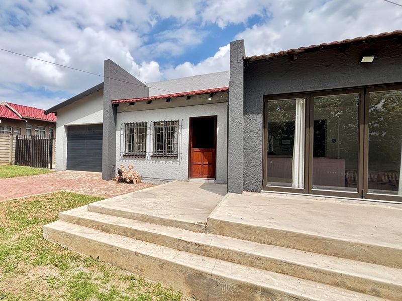 Front elevation of a modern-style house featuring a garage, concrete entrance steps, and large sliding glass doors leading to the interior.