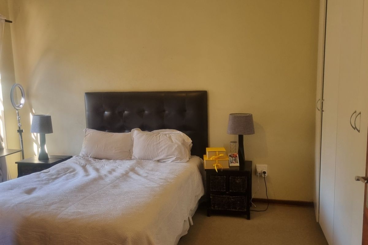 A standard bedroom featuring neutral wall finishes, carpeted flooring, and a built-in wardrobe for storage.
