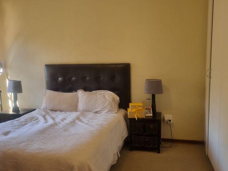 A standard bedroom featuring neutral wall finishes, carpeted flooring, and a built-in wardrobe for storage.