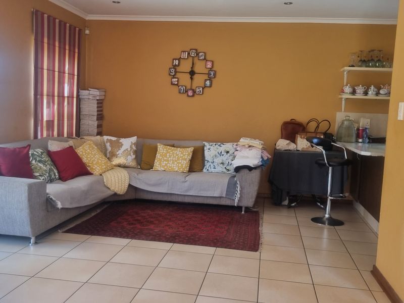 Open plan living area featuring tiled flooring, recessed downlights, and a built-in counter space, offering a functional layout for daily living.