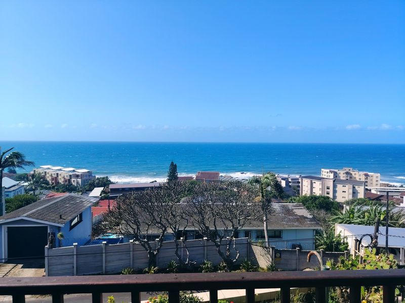 Elevated coastal view overlooking the neighborhood and ocean horizon, captured from a balcony.