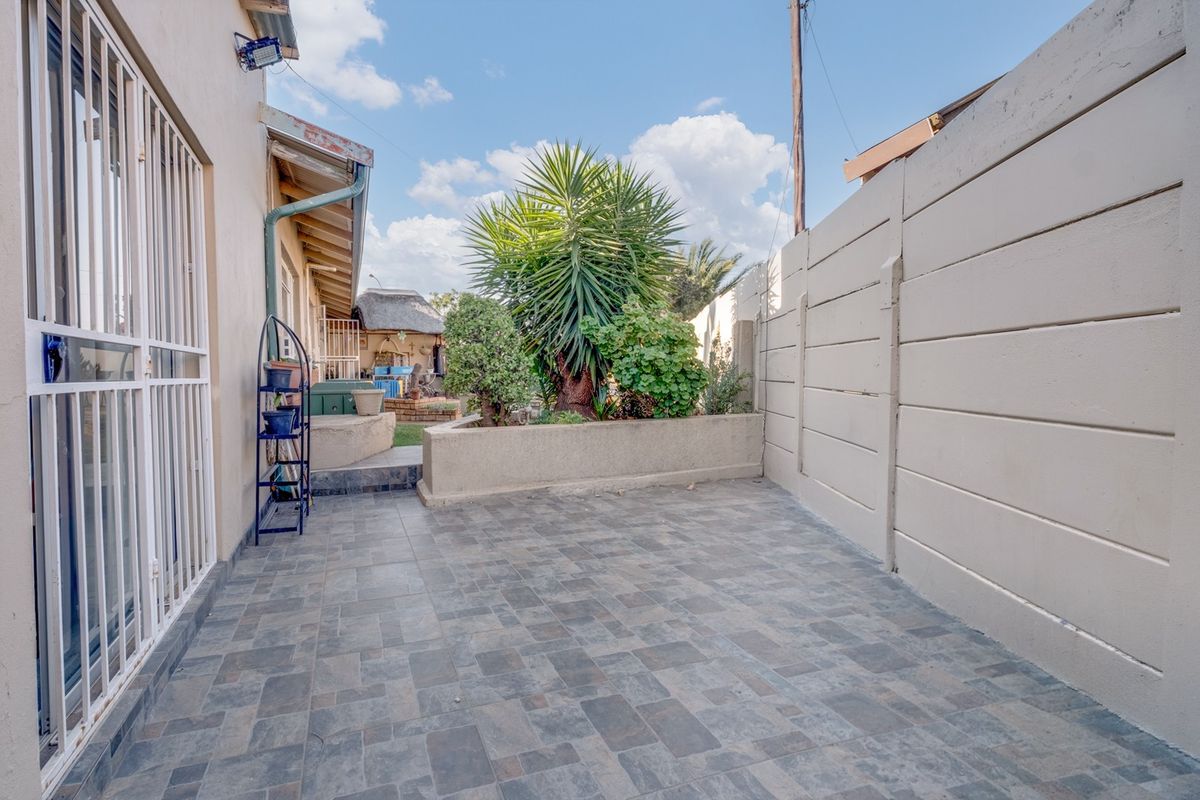 A paved rear patio area featuring a raised garden bed and secure boundary walling, providing a private outdoor space.