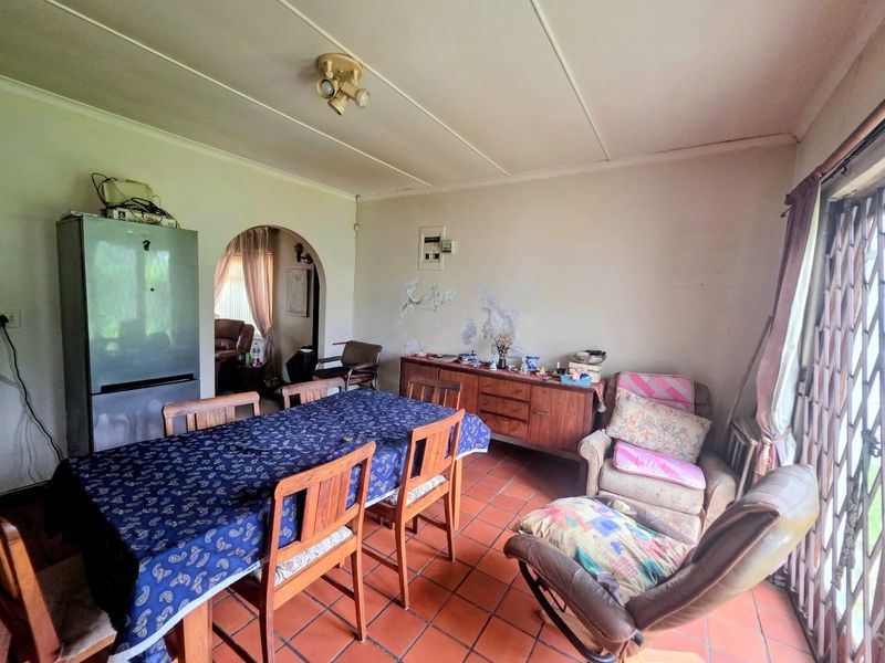 Dining room featuring terracotta floor tiles and an arched entryway, requiring cosmetic attention to the wall surfaces.