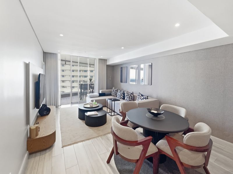 Modern open-plan living and dining area featuring tiled floors, recessed lighting, and seamless access to a private balcony through large sliding glass doors.