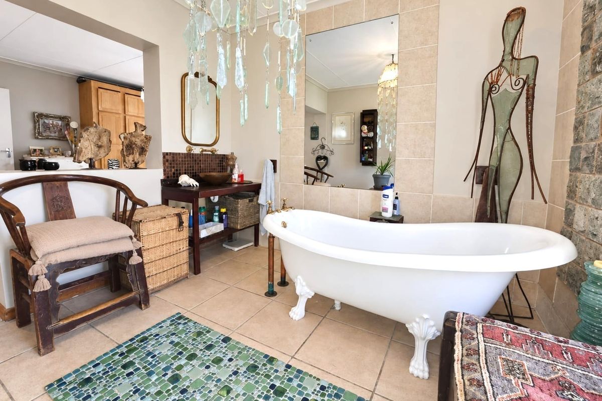 A bathroom featuring a classic clawfoot bathtub, tiled wall accents, and a vanity basin, creating a unique and character-filled space.