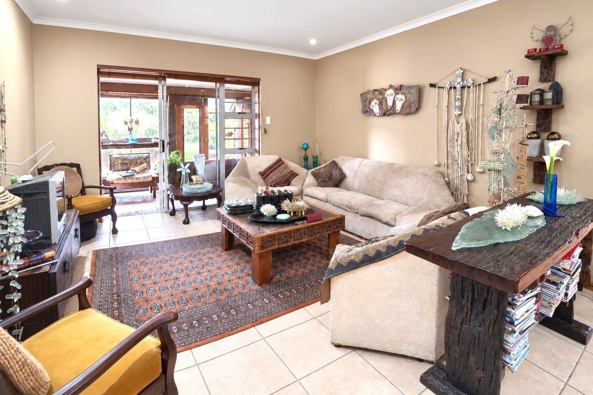 Spacious living room featuring tiled flooring, recessed lighting, and large sliding glass doors providing direct access to the outdoor patio area.