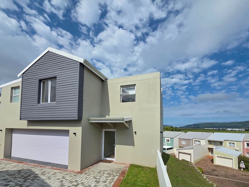 Front elevation of a modern two-story house featuring a garage, paved driveway, and contemporary cladding.